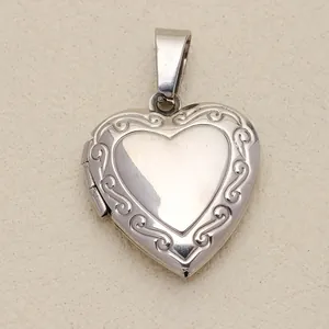 Detailed macro shot of vintage engraved silver heart locket pendant with scroll patterns