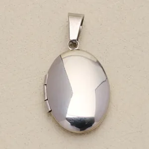 Macro view of a vintage polished silver oval locket pendant with a smooth mirror finish