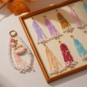 Close-up of colorful long beaded tassels and a decorative pearl keychain pendant.