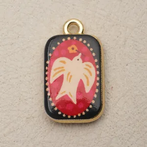 Detail macro view of a rectangular vintage copper pendant with a white bird illustration.