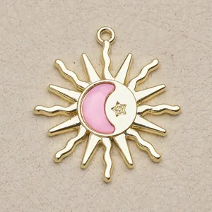 Detailaufnahme eines vergoldeten Kupfer-Sonne-Anhängers mit rosa Mond für DIY-Schmuck
