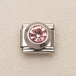 Macro dettaglio di un charm modulare in acciaio inossidabile con cristallo rosa per bracciali.