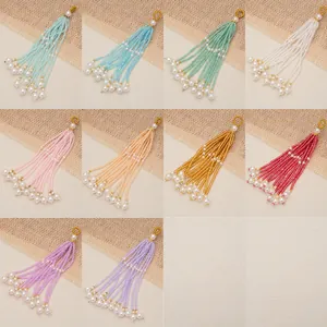 Detailed view of colorful multi-strand beaded tassels with pearl ends for DIY jewelry
