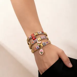 Gros plan d'un bracelet modulaire italien bicolore en acier inoxydable avec des breloques