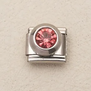 Dettaglio di pietra di cristallo rosa incastonata in maglia charm italiana in acciaio