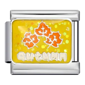 Détail macro d'un charm jaune scintillant avec feuilles d'érable et texte Autumn
