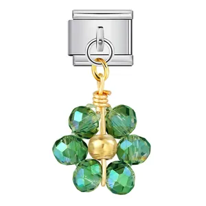 Close-up detail of faceted green crystal beads forming a flower on a gold-wired charm