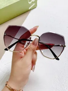 Primer plano de gafas de sol degradadas moradas sin montura con lentes de corte geométrico.
