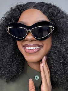 Close-up of stylish black cat-eye sunglasses with gold metal accents on a model