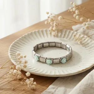 Vista de detalle de una pulsera italiana de acero inoxidable con flores de color verde