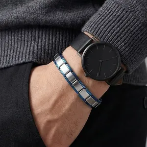 Close-up of blue and silver stainless steel modular DIY bracelet links on a wrist.