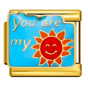 Detail view of a 9mm gold Italian charm link with sun design and You are my text