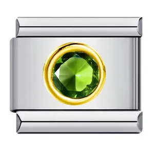 Gros plan d'un charm modulaire italien avec une pierre verte et un sertissage en or