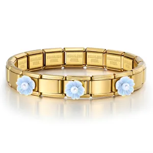 Vista detallada de pulsera modular de acero dorado con flores azules y perlas