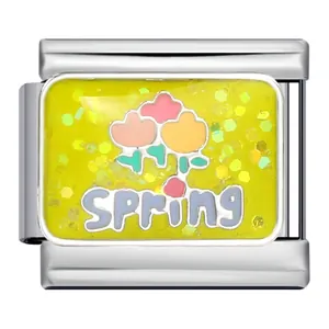 Gros plan d'un charm italien en acier inoxydable avec paillettes jaunes et fleur SPRING.