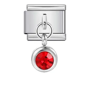 Dettaglio di charm modulare italiano in acciaio con ciondolo a pietra portafortuna rossa.