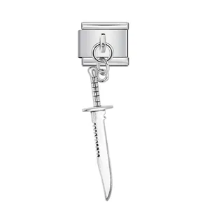 Détail macro d'un charm italien en acier inoxydable avec un pendentif couteau tactique.
