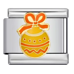 Primer plano de un dije italiano de acero con una bola de Navidad en esmalte amarillo.