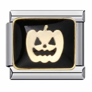 Macro detail of a gold pumpkin charm on black enamel for Italian modular bracelet