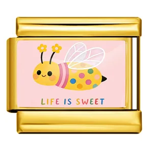 Vista detallada de un amuleto italiano dorado con una abeja y el texto Life is Sweet