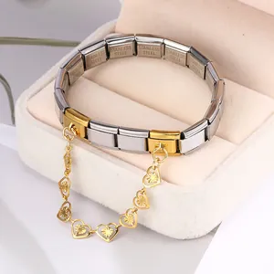 Detail view of a stainless steel Italian modular charm bracelet with gold heart dangle chain
