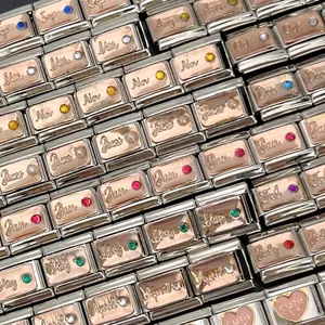 Primo piano di charm italiani in acciaio inox con pietre natali e incisioni dei mesi