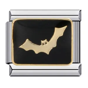 Macro view of a stainless steel Italian charm with a golden bat on black background