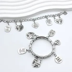 Close-up of stainless steel modular and link charm bracelets with engraved pendants