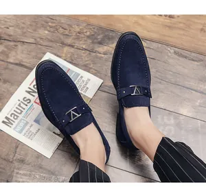 Macro view of navy blue suede men's loafers with metallic V-buckle detail