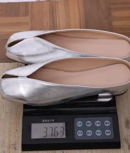 Detalle de los mules plateados metalizados en una báscula digital con su peso
