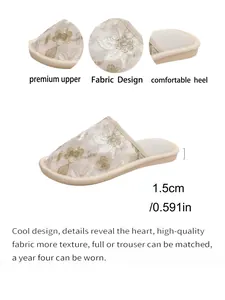 Detailansicht der bestickten Hausschuhe mit 1,5 cm flachem Absatz und floralem Stoffdesign