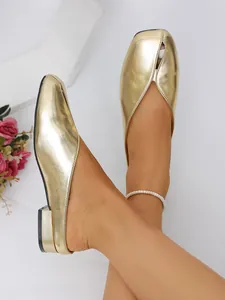 Vista detallada de mules planos dorados para mujer con textura de cuero arrugado único