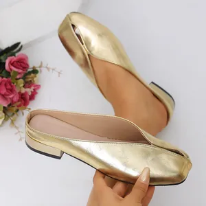 Elegantes mules planos dorados metalizados con punta fina para mujer.