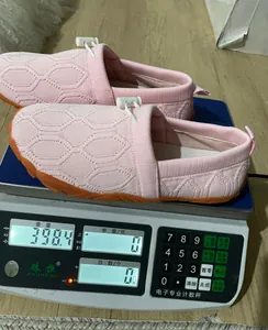 Leichter rosa Fly-Knit-Barfuß-Sportschuh, der 398,4 g auf einer Digitalwaage wiegt