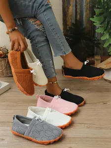 Nahaufnahme bunter Flyknit-Barfußschuhe für Damen mit rutschfester orangefarbener Sohle.