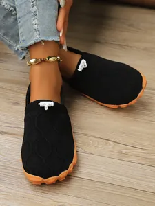 Detailansicht atmungsaktiver schwarzer Barfuß-Strickschuhe für Damen mit oranger Sohle.