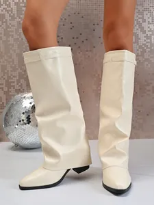 Bottes hautes en cuir beige avec talons épais dans un studio de mode très tendance.
