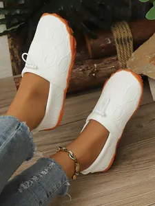 Nahaufnahme weißer, atmungsaktiver Outdoor-Barfußschuhe mit orangefarbener Antirutschsohle
