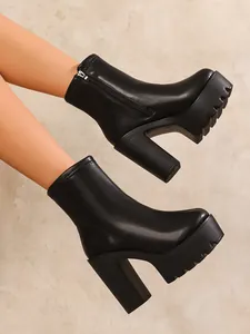 Side view of black platform chunky high heel boots with side zipper and textured sole.