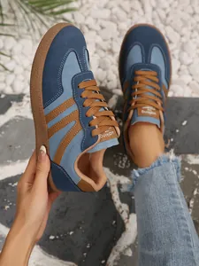 Close-up of retro blue patchwork women's GAT sneakers in an outdoor setting