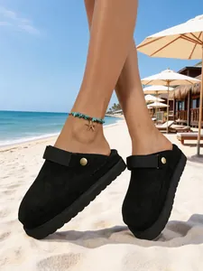 Élégants sabots à plateforme en daim noir pour femmes dans un décor de plage ensoleillé