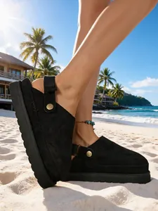 Sabots à plateforme noirs élégants avec bride réglable et boucle dorée sur la plage