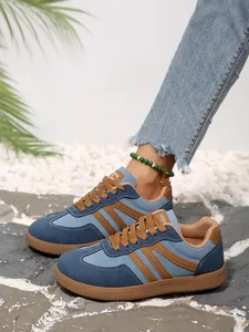 Side view detail of retro color-block women's sneakers on a rocky beach background
