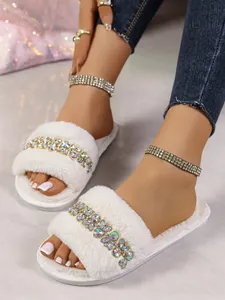 Vista dettagliata delle pantofole di peluche bianche da donna con eleganti strass colorati