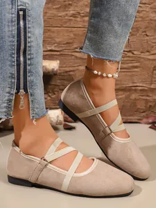 Primo piano di eleganti ballerine Mary Jane in camoscio beige con elastici incrociati