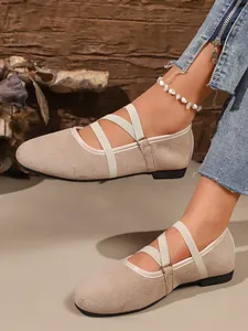 Dettaglio di ballerine Mary Jane in camoscio beige con elastici incrociati chic.