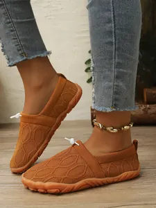 Nahaufnahme der atmungsaktiven orangefarbenen Barfußschuhe für Damen auf dem Holz