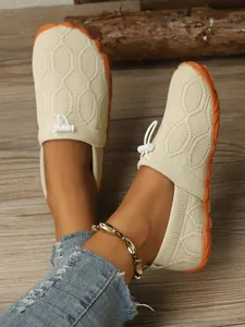 Detailansicht beige atmungsaktive Fly-knit Barfuß-Sportschuhe für Damen auf Holzboden.