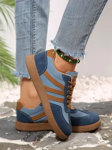 Detailed close-up of retro color-block German Army Trainers sneakers on feet.