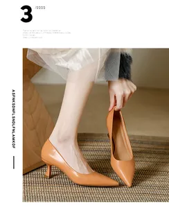 Gros-plan sur des escarpins orange à bouts pointus et talons aiguilles en cuir souple.
